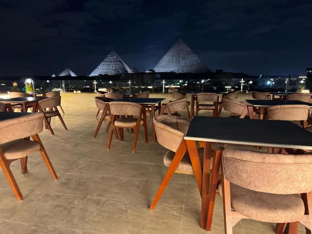 Night rooftop view of the illuminated Giza Pyramids at Dyafa Pyramids Hotel and Spa